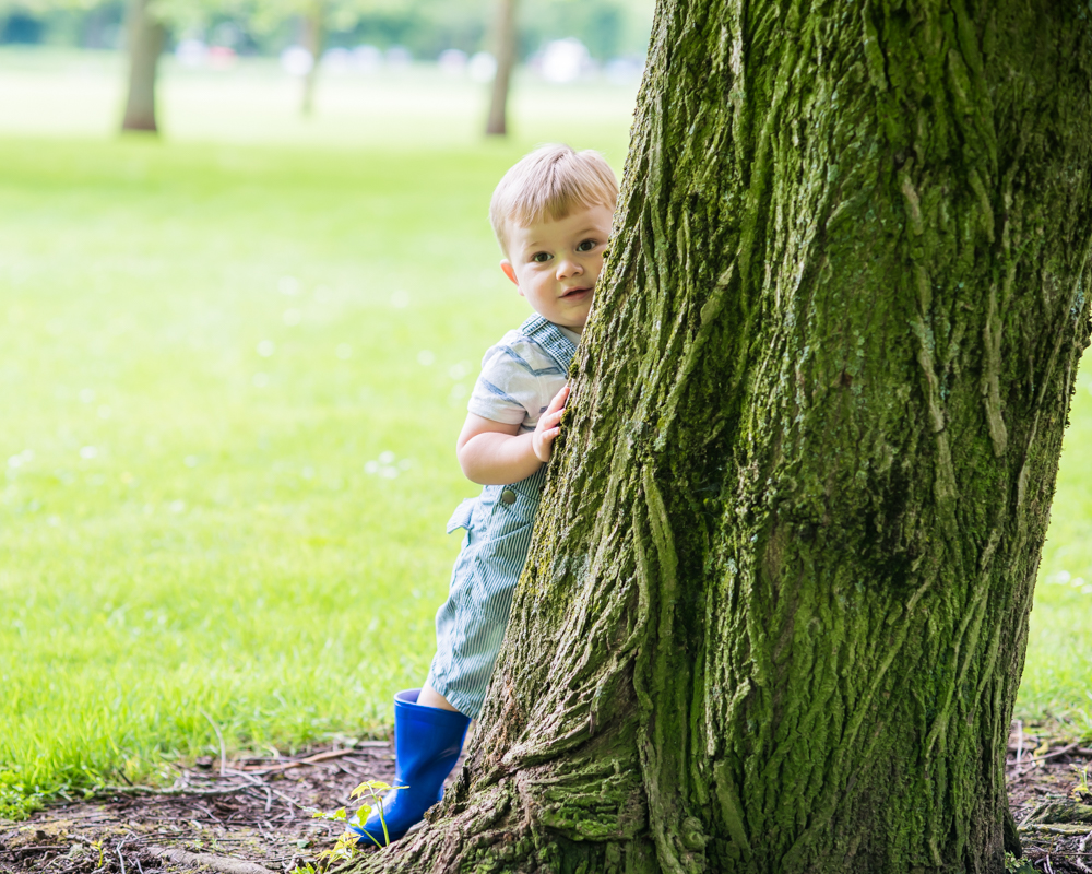 Freddie hiding behind tree, Carlisle family portraits in Bitts Park