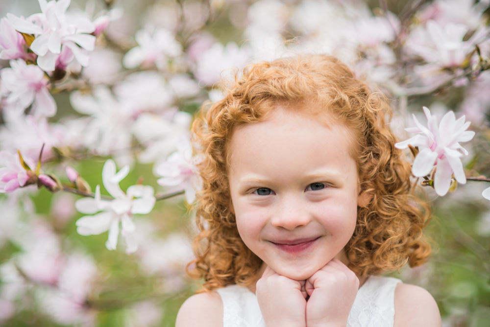 Smiling in front of blossom tree, baby photographers Cumbria
