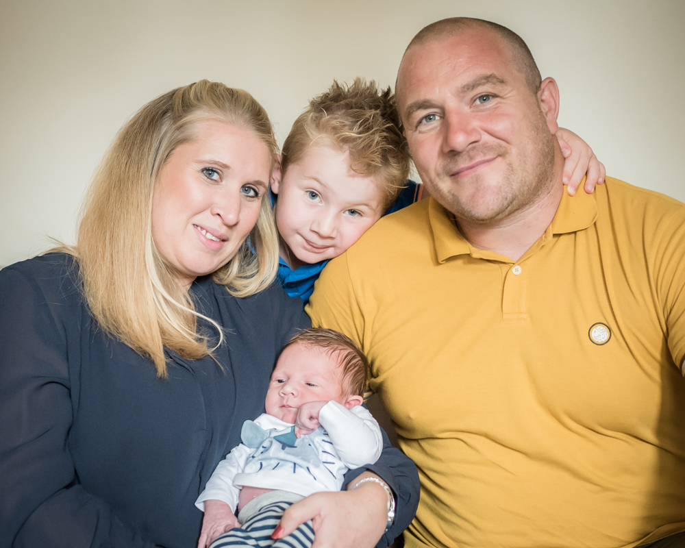 Joshua in the middle of family sandwich photo, newborn photographers Cumbria
