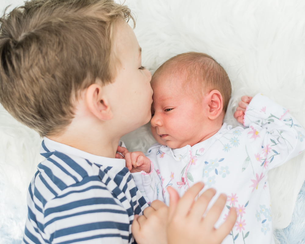 Jacob kissing his sister Delphie,  family portraits Wigton newborn photographers