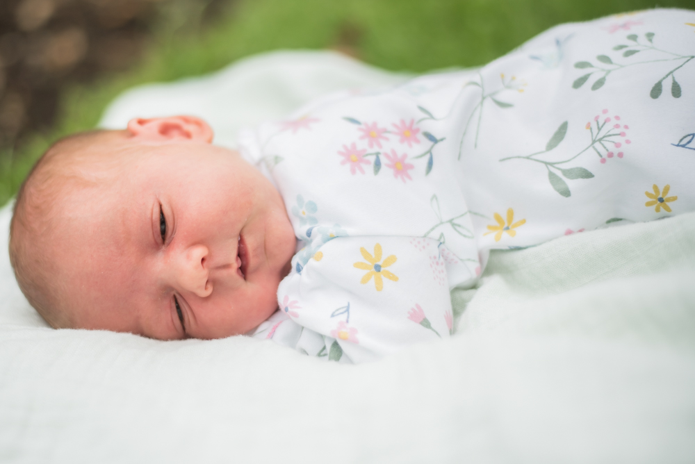 newborn Delphie lying on the grass,  family portraits Wigton newborn photographers