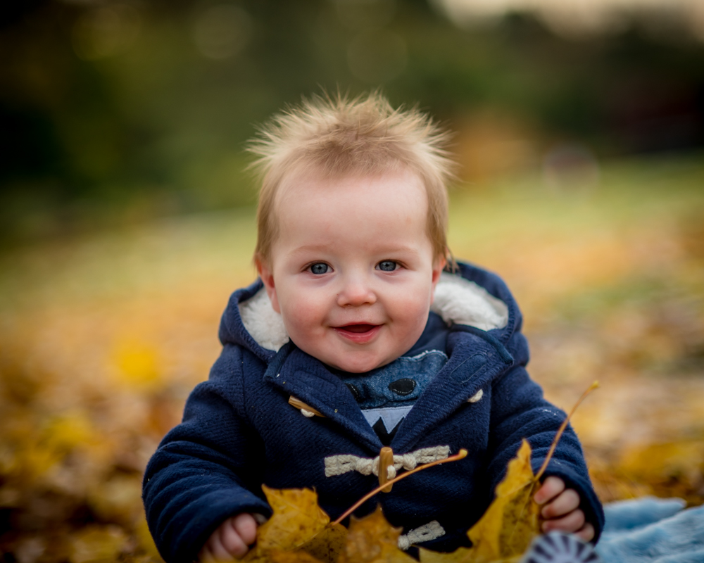 Smiling Hugo in leaves, baby portraits Keswick